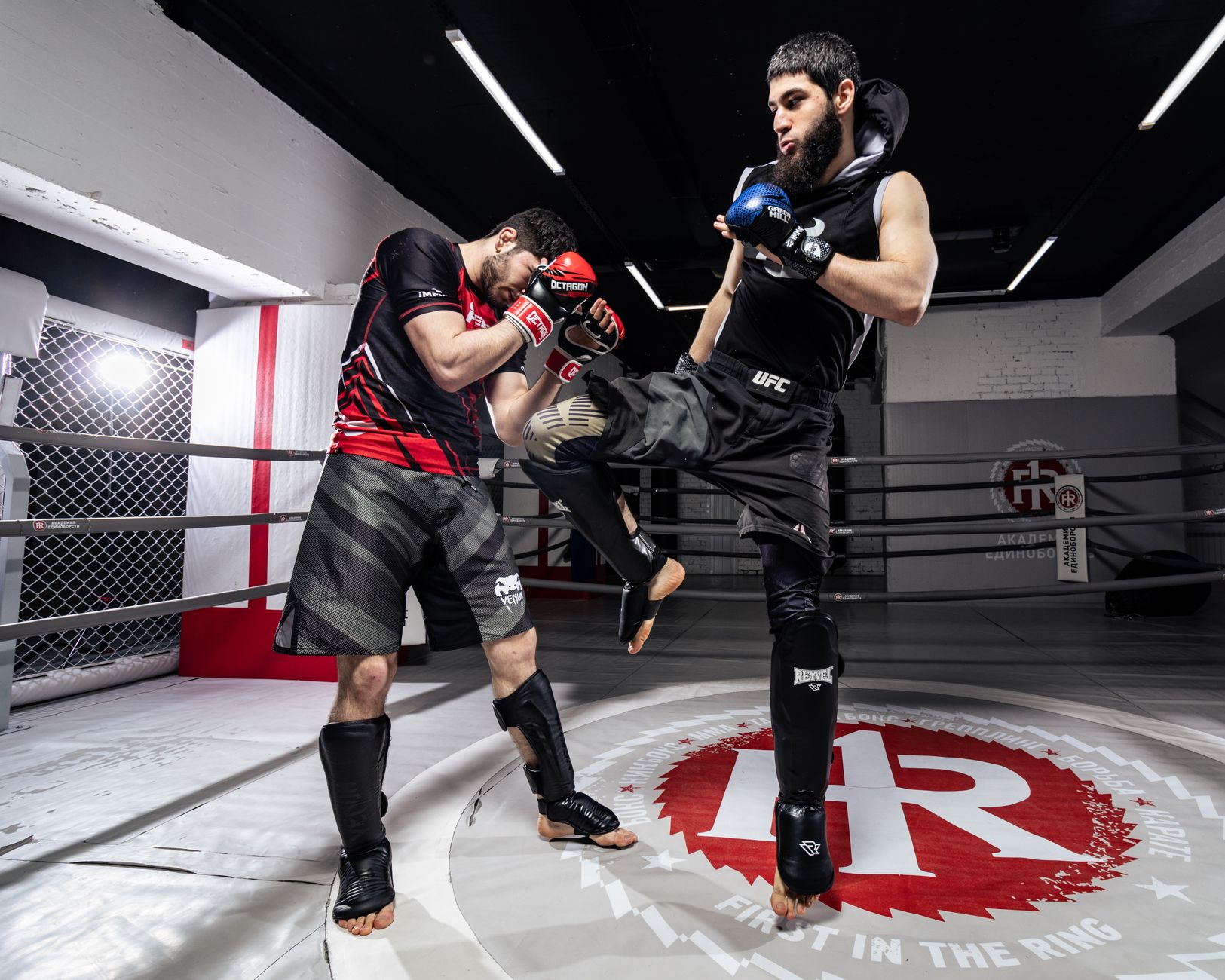 Two men practicing kickboxing in a gym, showcasing dynamic motion and technique.