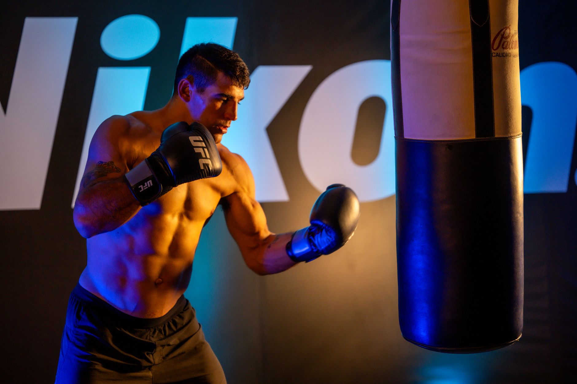 Muscular athlete boxing in a Mexico City gym, showcasing fitness and strength.