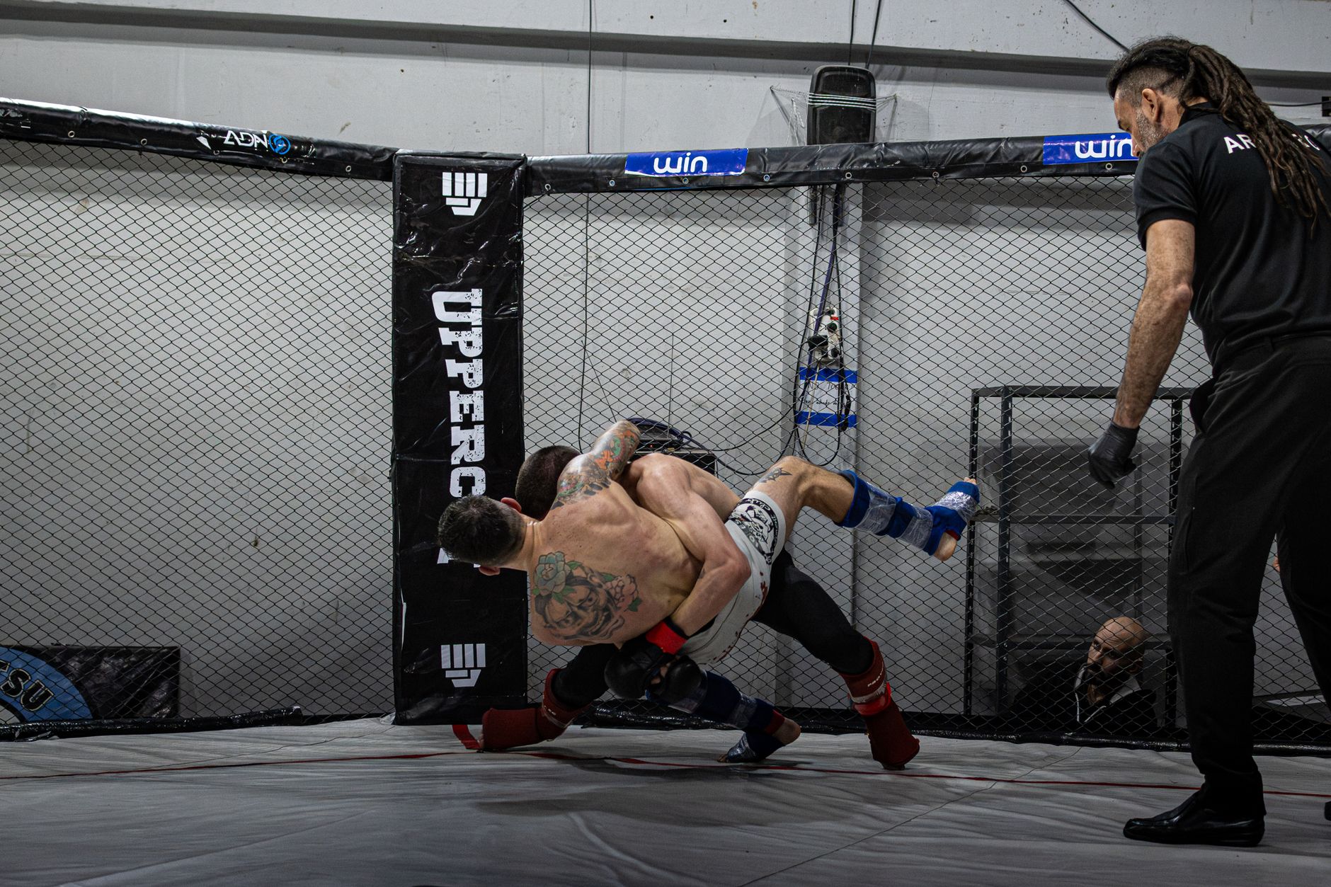 Two MMA fighters battling in a cage during a match in Buenos Aires.