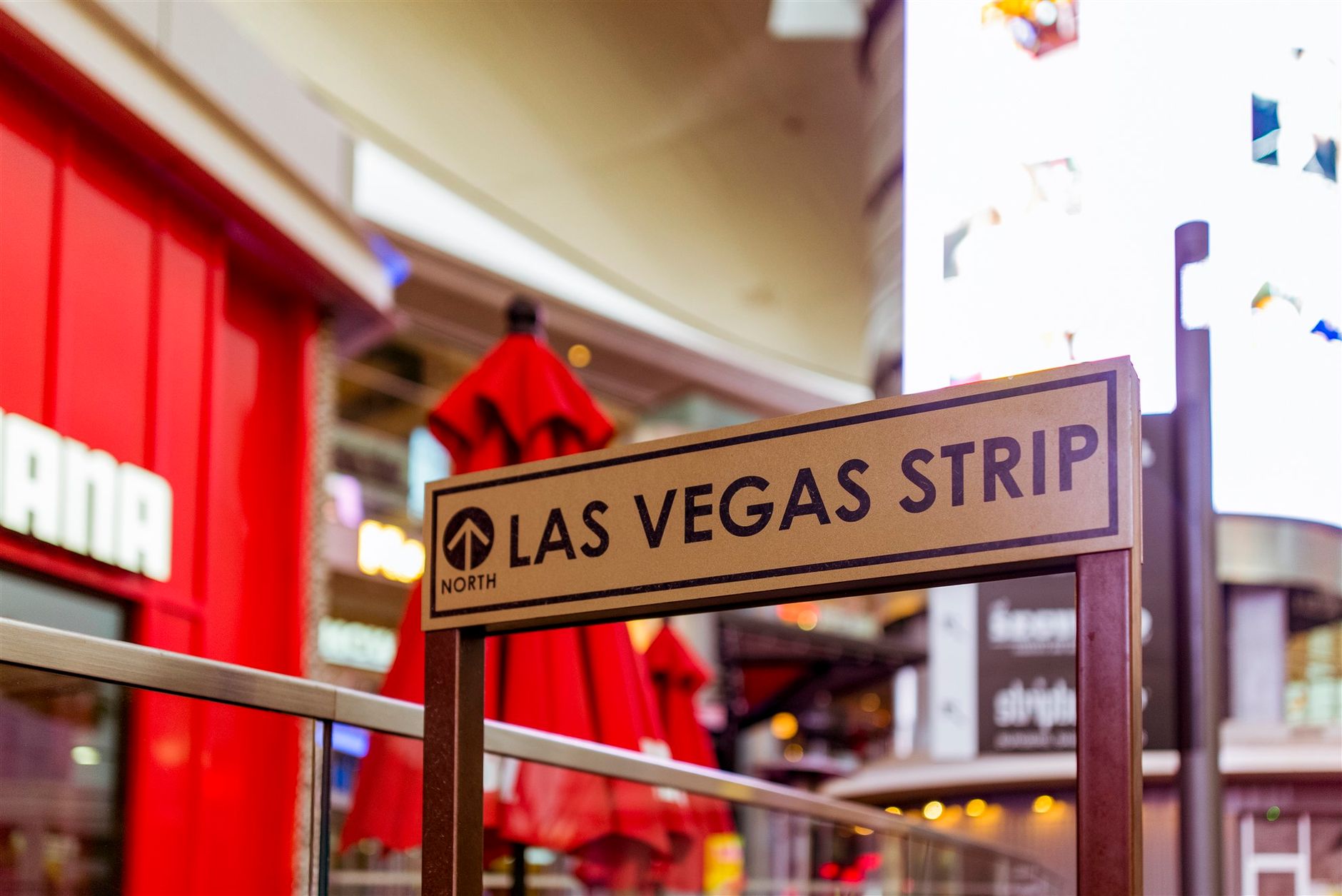 Iconic Las Vegas Strip sign with vibrant city life background.