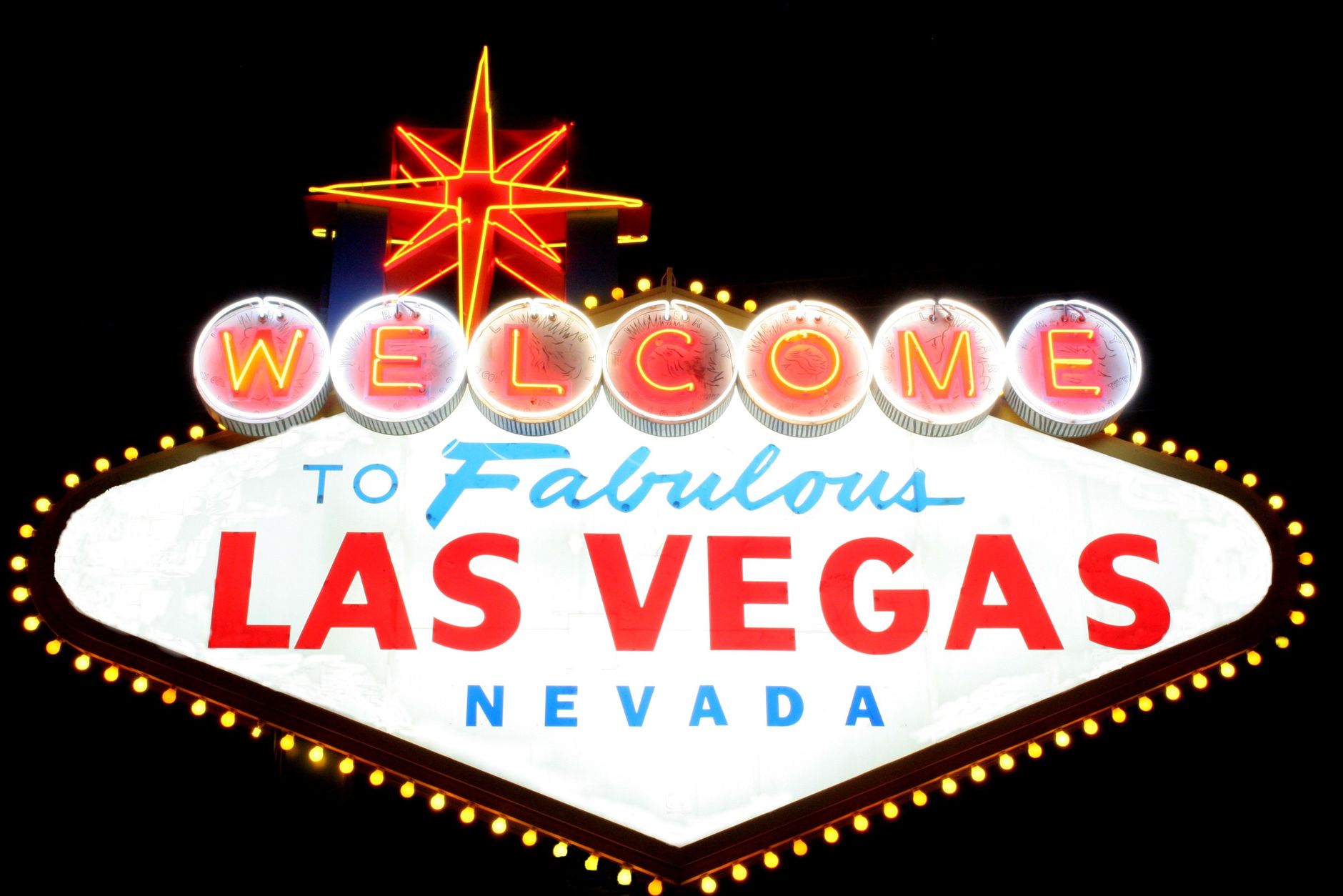 Bright neon 'Welcome to Las Vegas' sign glowing against the night sky, representing the vibrant city life.