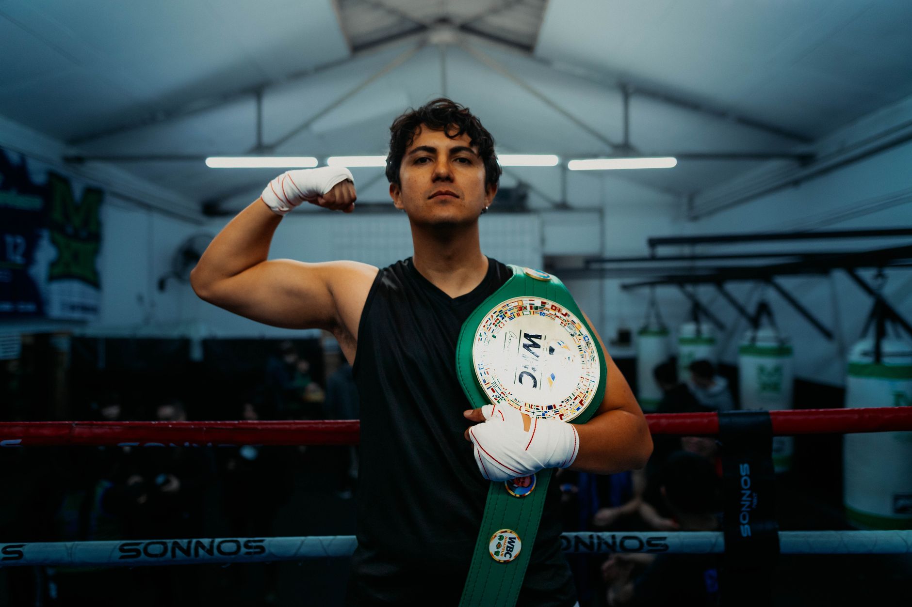 Boxer proudly displaying championship belt in a Buenos Aires gym, ready for victory.