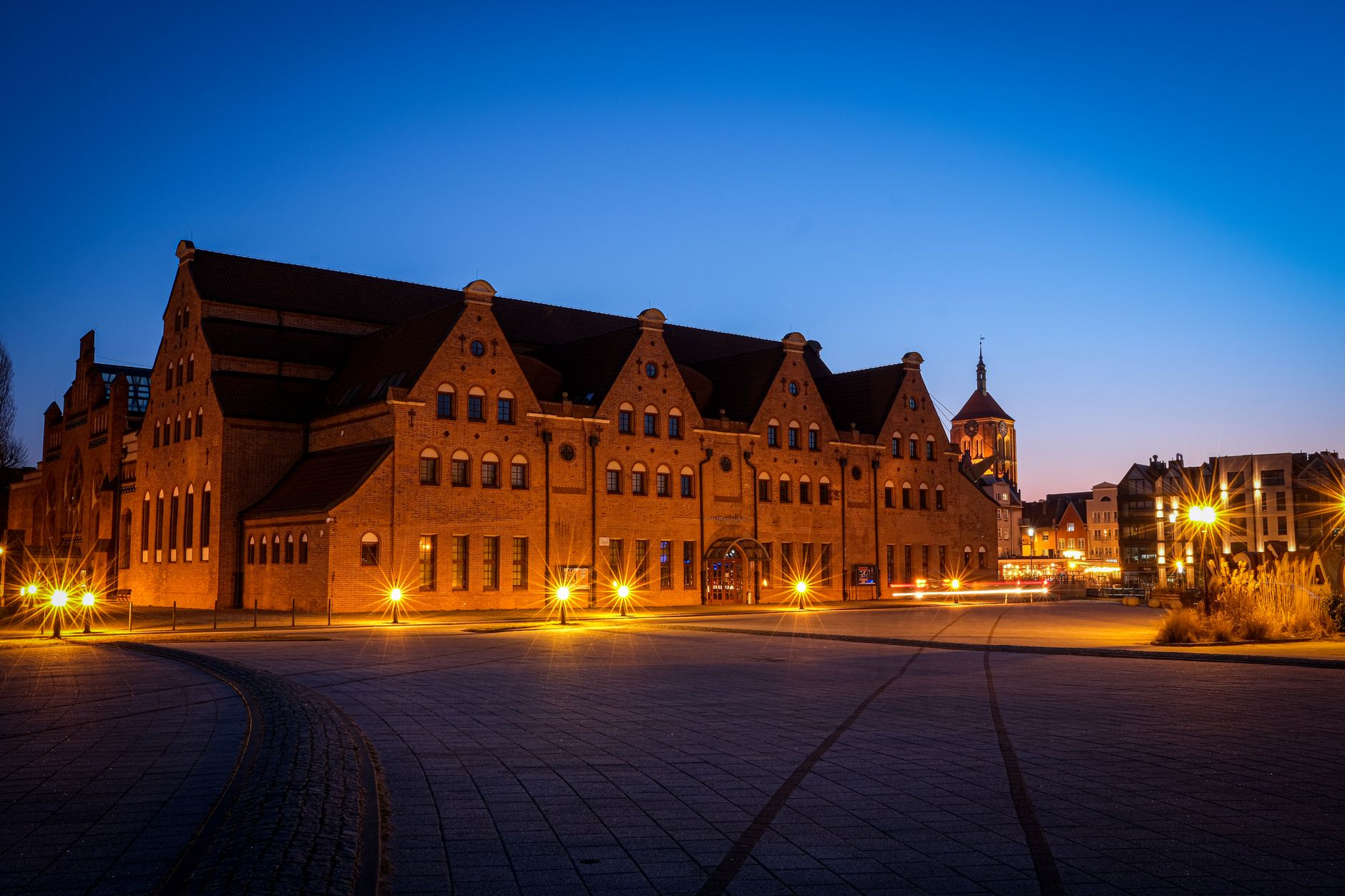 A stunning night view of an illuminated neo-gothic building in Gdańsk, Poland.