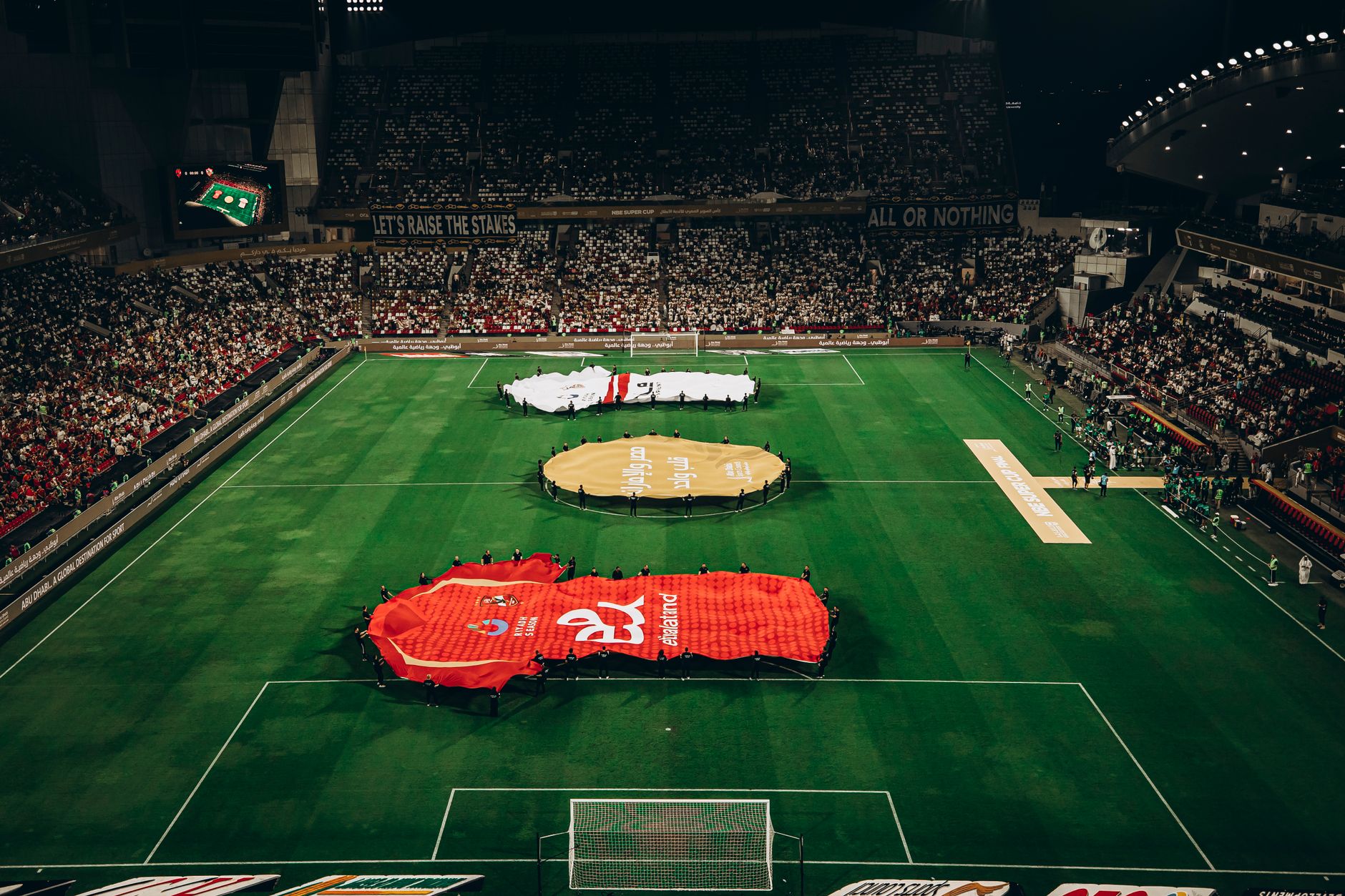 Aerial shot of a football match in Abu Dhabi stadium filled with enthusiastic fans.