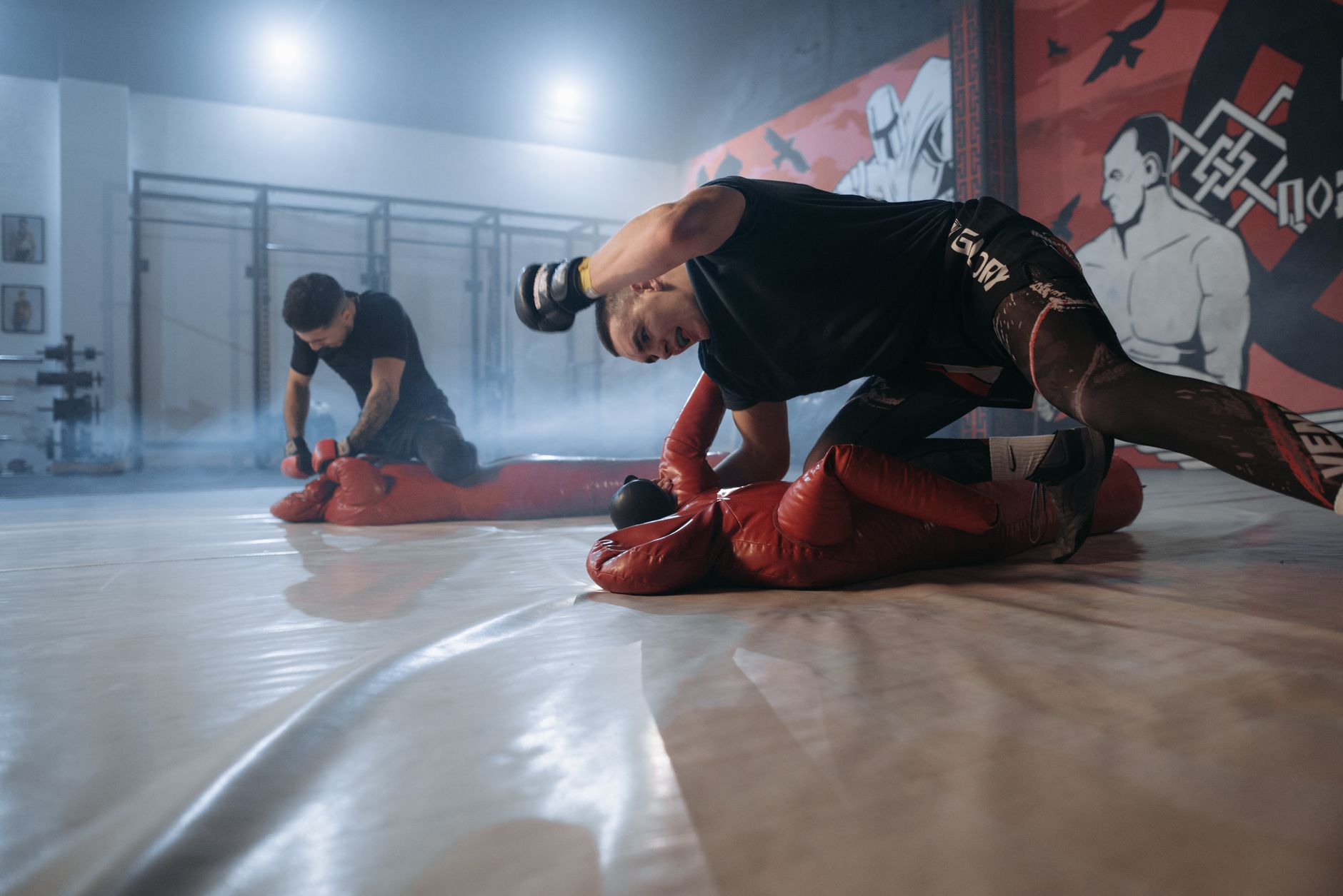 Intense indoor sparring session in a martial arts gym, showcasing strength and skill.