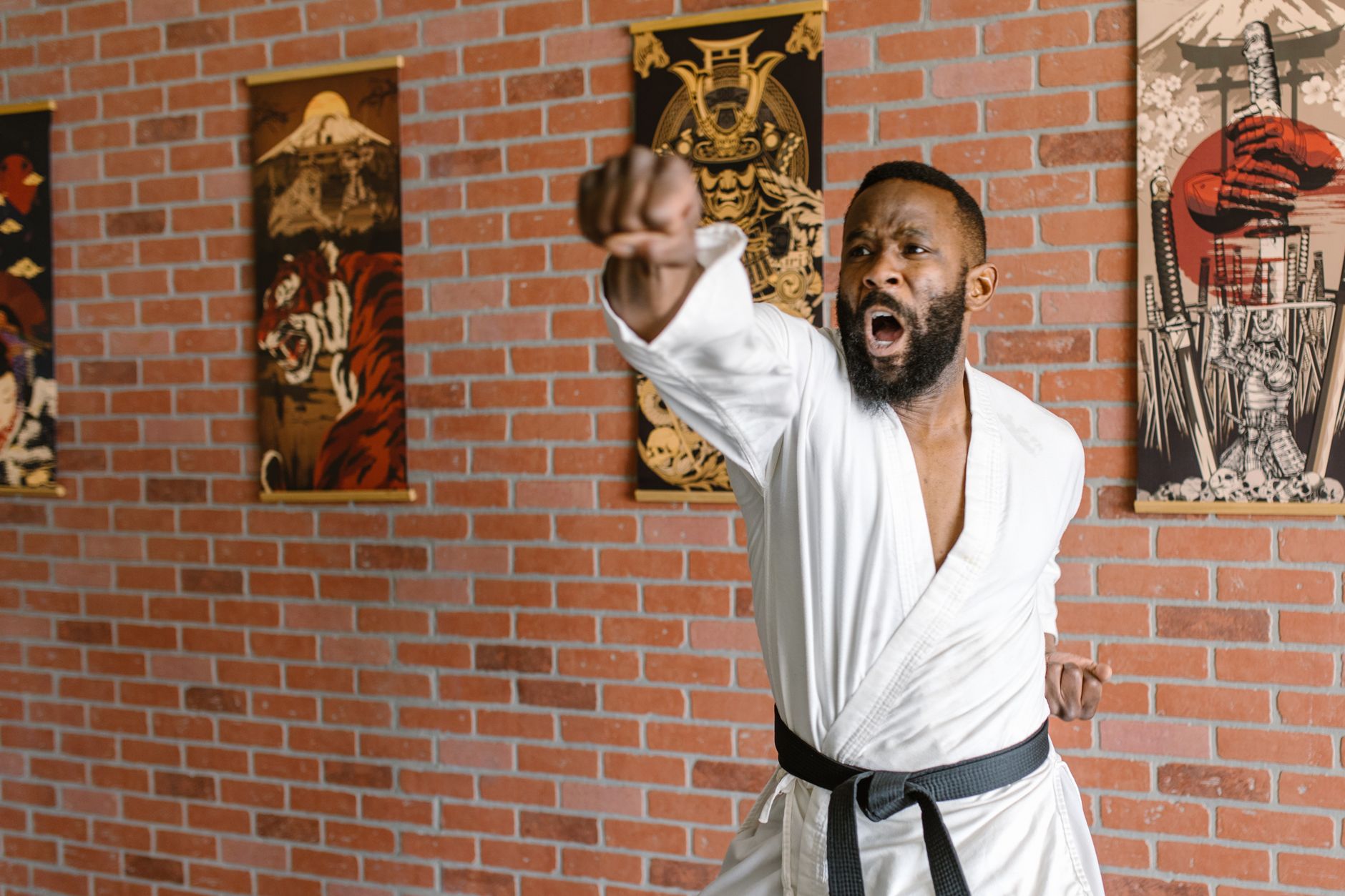 Karate practitioner in a dojo executing a punch with focus and intensity.