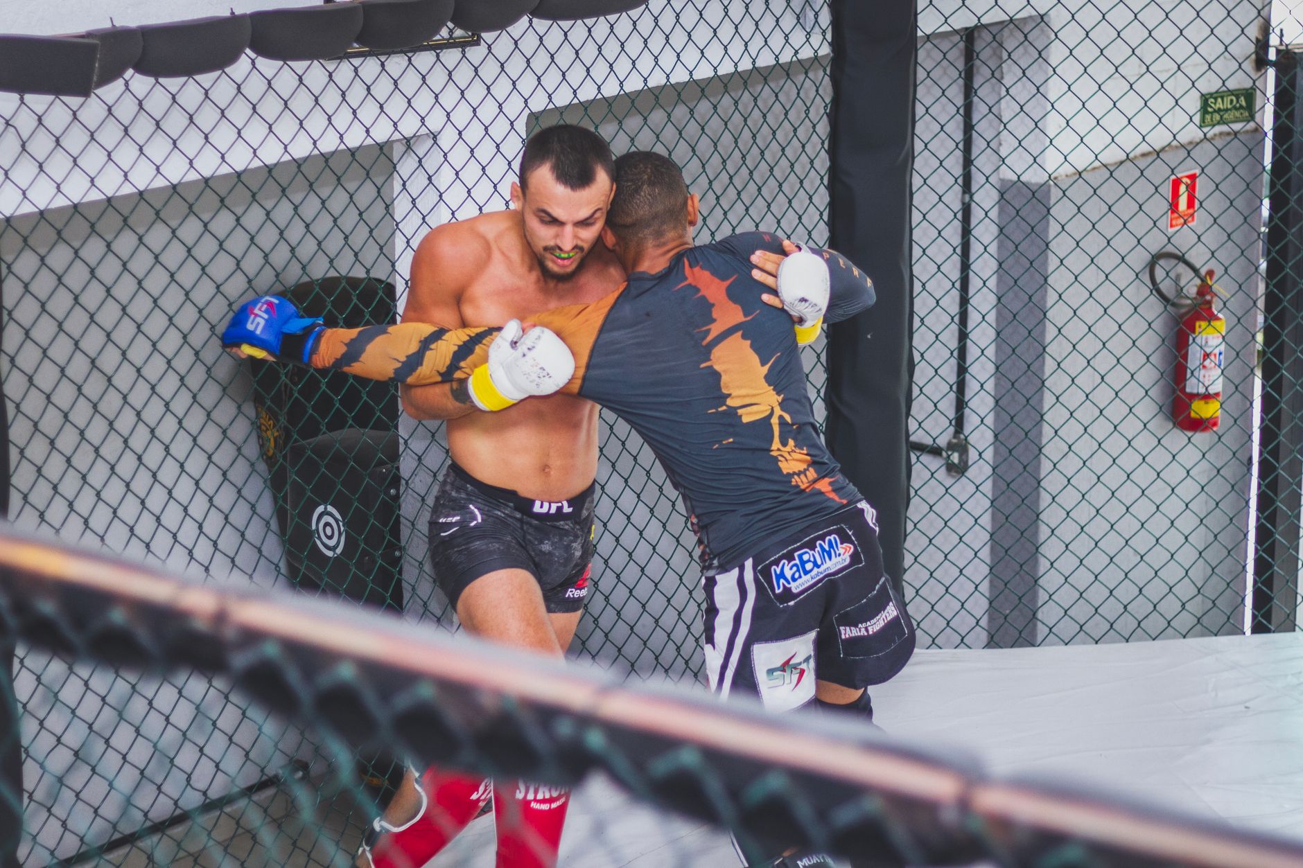 Two male fighters engaged in an MMA match demonstrating strength and agility.