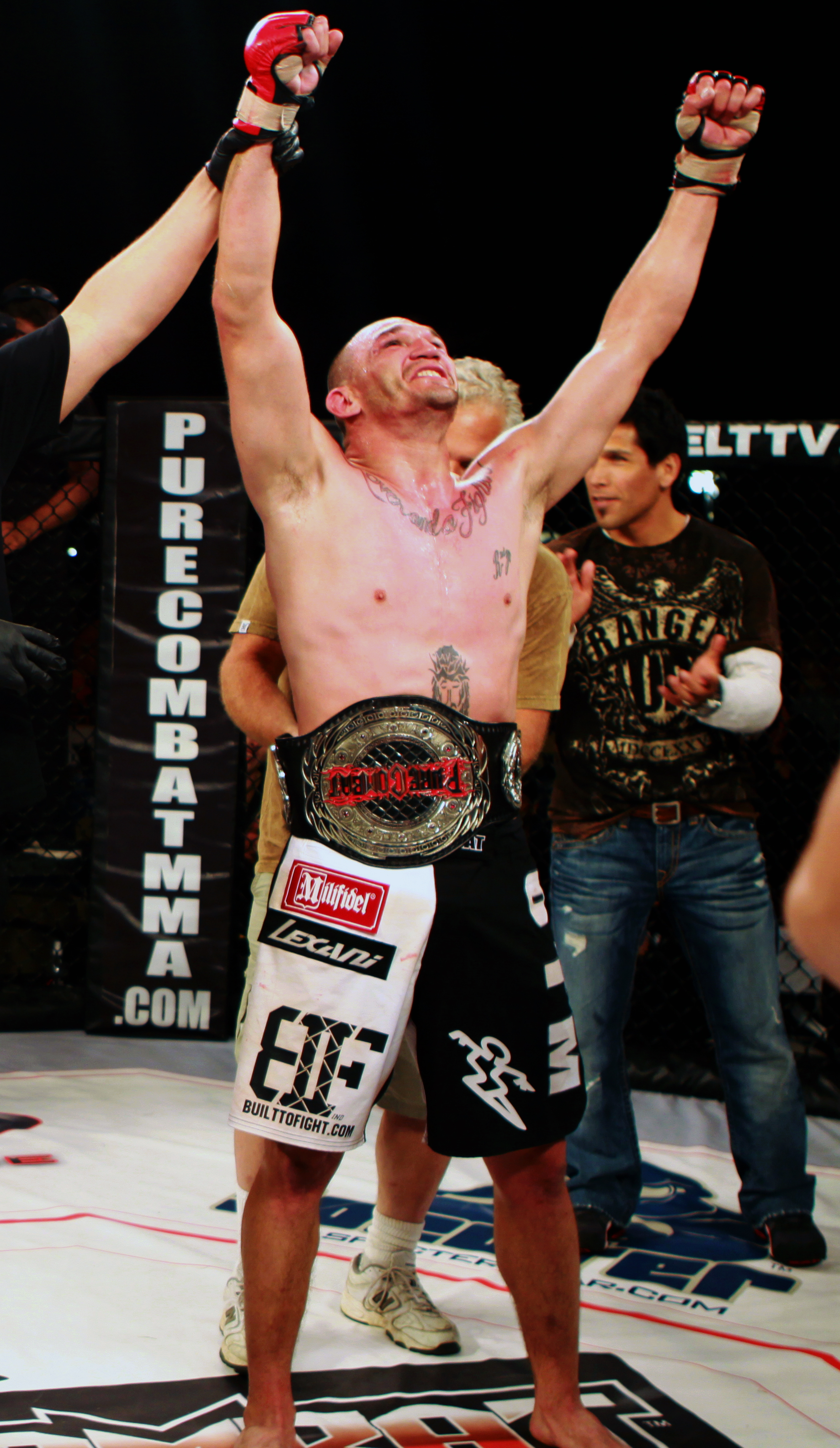 Mixed Martial Artist Anthony Ruiz, raises his arms in victory after winning the PureCombat championship belt from Kenny “The Crusher” McCork