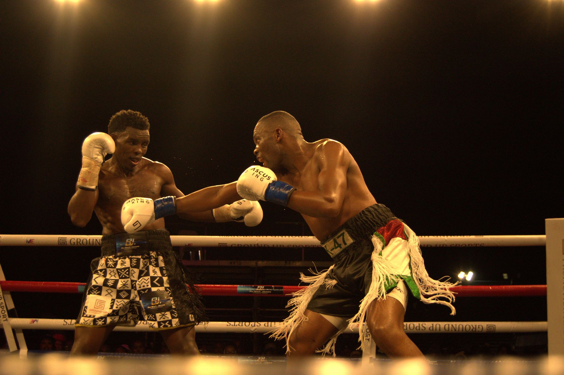 Two athletes in an intense boxing match at KuGompo City arena. Action-packed and energetic competition.