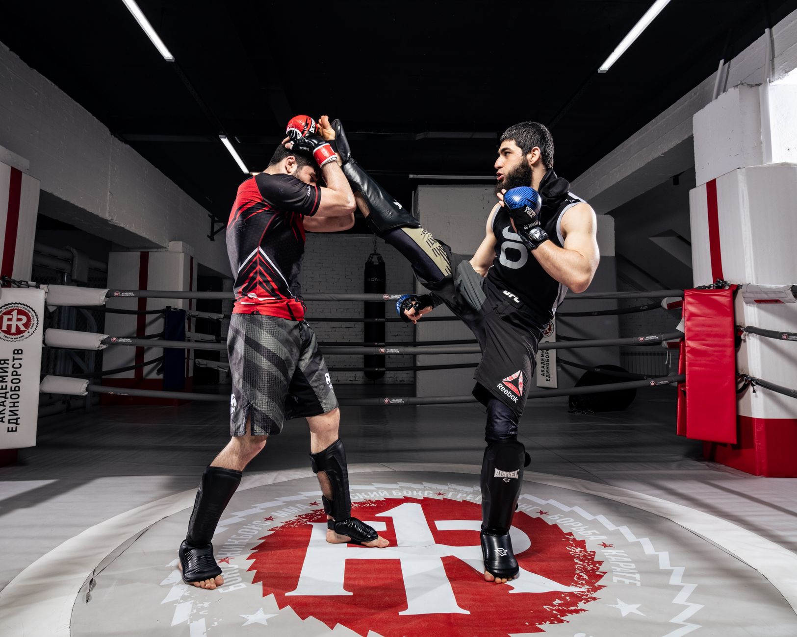 Dynamic kickboxing fight between two men in an indoor boxing ring.