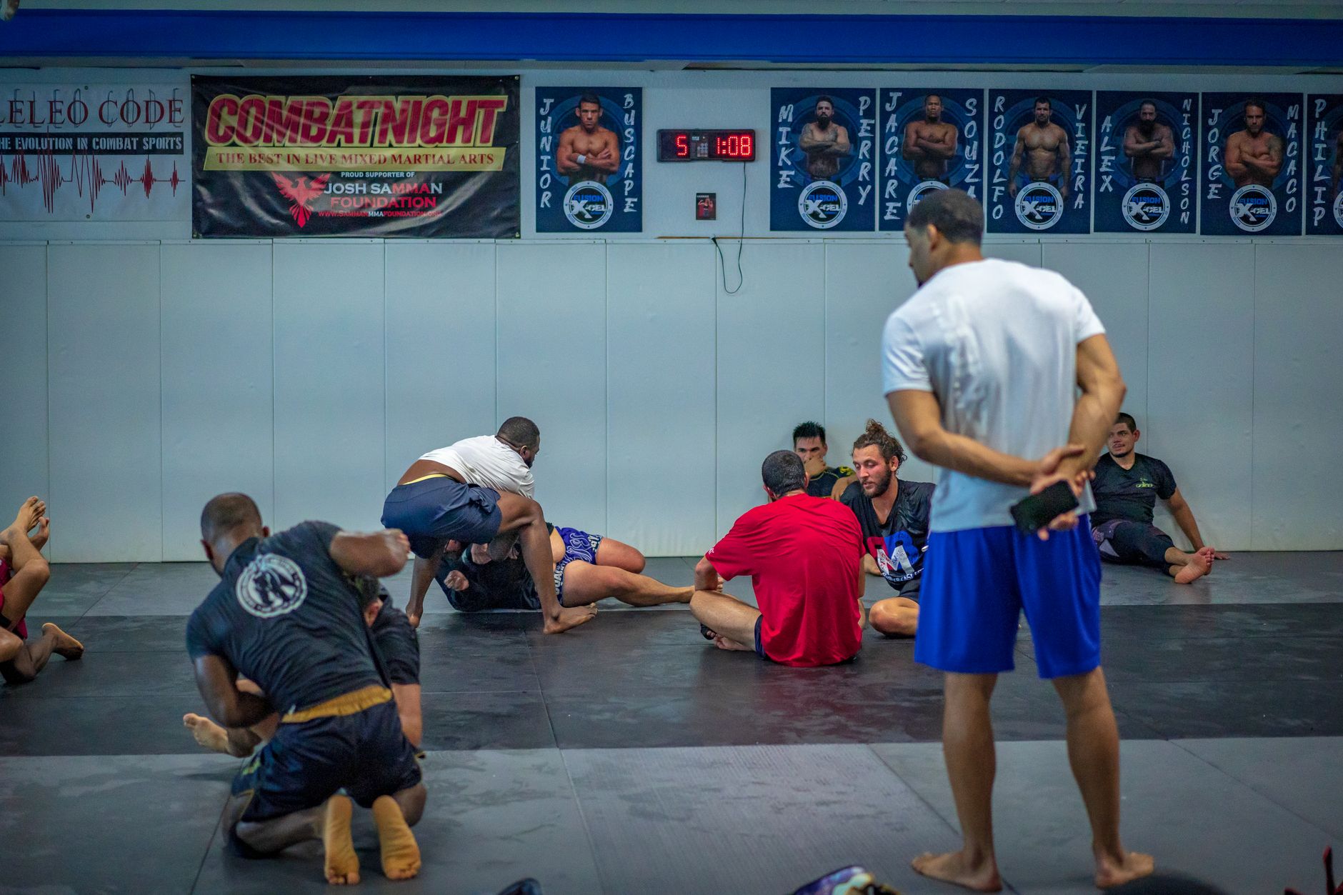 Mixed martial arts fighters practicing techniques during a gym session.