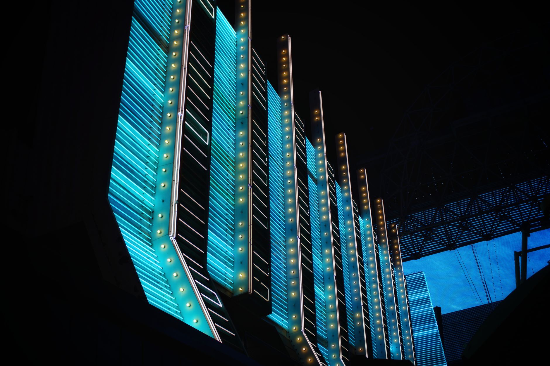 Vibrant neon lights illuminate modern architecture in the heart of Las Vegas at night.