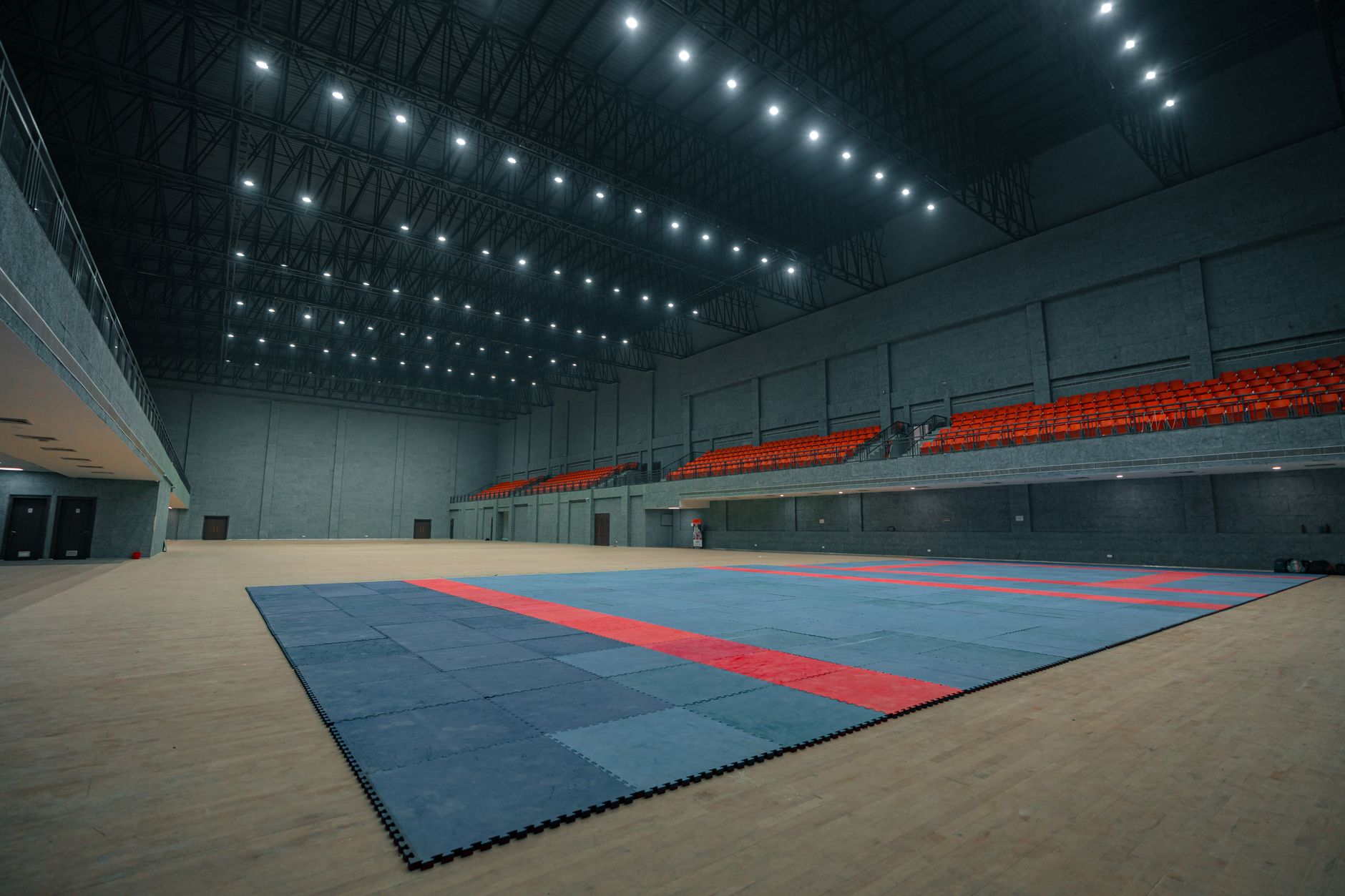 Large indoor sports venue in Surat, India, with ample seating and matted flooring.